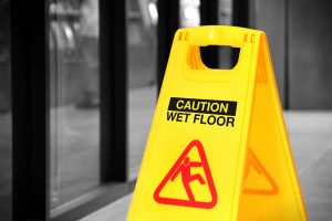 A sign indicating wet floors as a trip hazard.