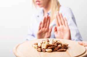 A woman who is allergic to nuts refusing to eat them.
