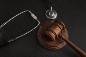 A gavel and a stethoscope sit on a black background