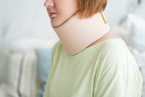 Woman in a neck brace for whiplash after a road traffic accident.