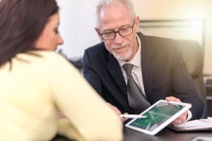 A NO WIN NO FEE SOLICITOR EXPLAING HOUSING DISREPAIR CLAIMS ON A TABLET TO HIS CLIENT