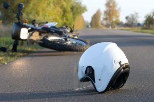 MOTORBIKE AND DISCARDED CRASH HELMET IN THE AFTERMATH OF A FATAL ACCIDENT. 