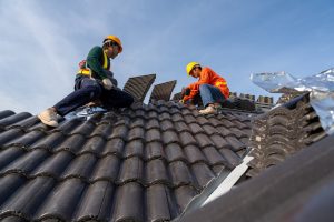 TWO-WORKERS-CARRYING-OUT-HOUSING-DISREPAIR-IMPROVEMENTS-ON-A-ROOF-TOP.