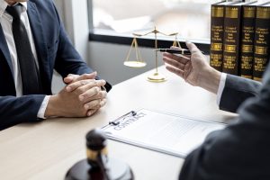 Two solicitors discuss a minor injury claim at a desk with scales and gavel. 