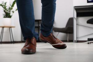 Man tripping over wire in office.