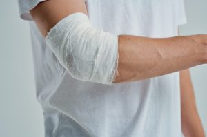 Man with bandage on elbow injury.