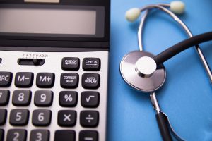 A misdiagnosis compensation calculator and a stethoscope on a table.