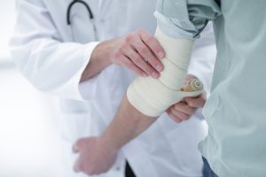 A person with bandaged arm, who will use an elbow injury claim calculator.