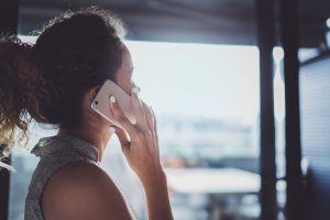 A woman with a ponytail talks on a mobile phone.