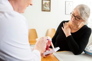 A doctor explains a rotator cuff tear to a patient.