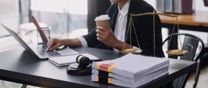 No Win No Fee solicitor sits at a cluttered desk researching your accident at work claim. 