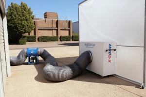 MOBE-X unit and hose beside a ROLARE-FLEX enclosure outdoors